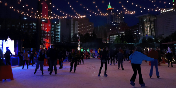 a photo of skaters at an outdoor ice rink